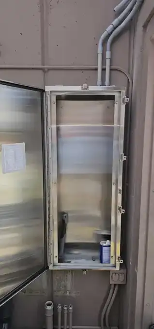 The new stainless steel NEMA 4X panel can, open — conduits landed in the top, circuit directory on the door.